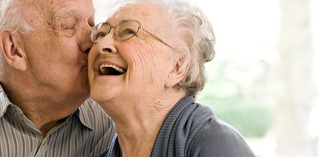 senior man kisses his wife on the cheek