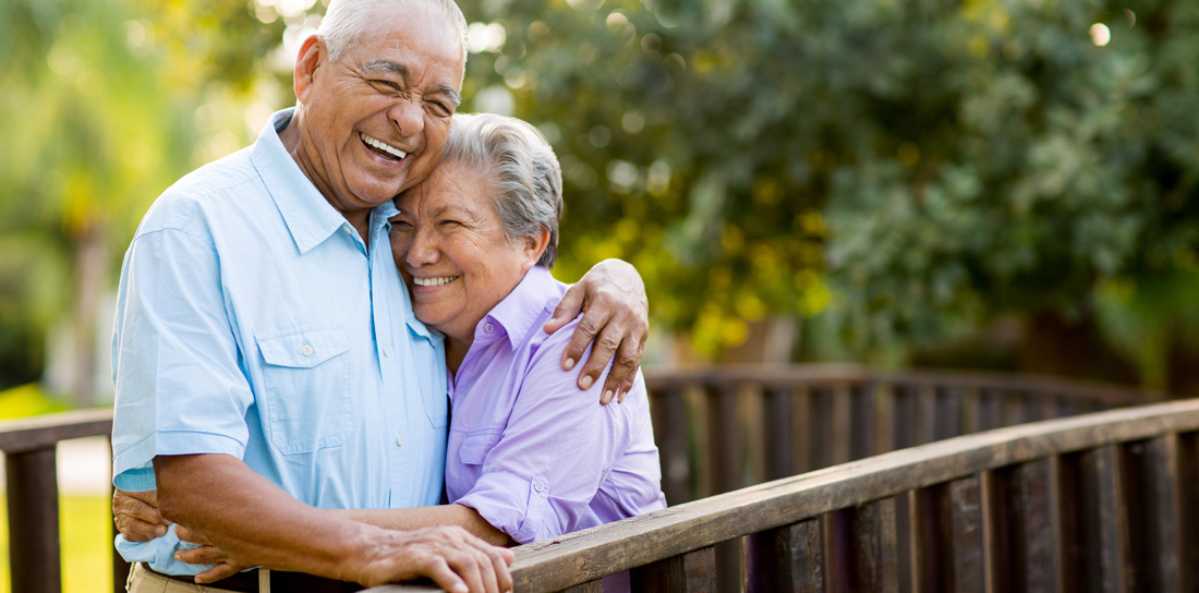 hispanic senior couple embracing and laughing