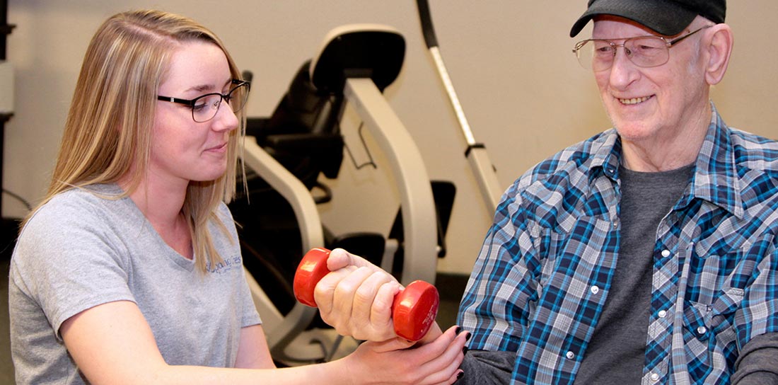 physical therapist works with senior man