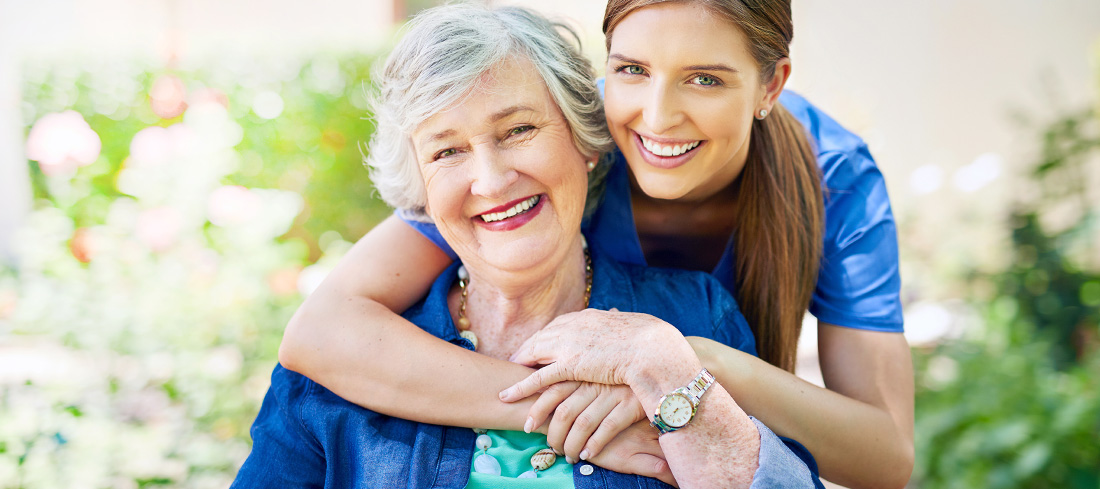 smiling young woman embraces older woman