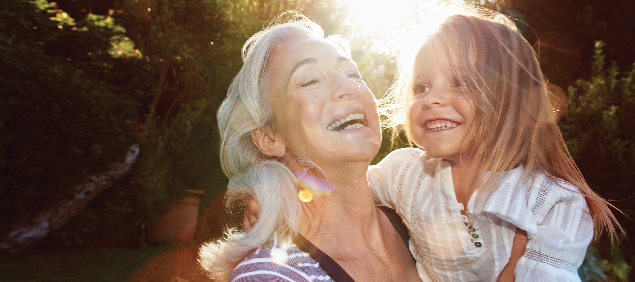 grandmother holds laughing grandaughter