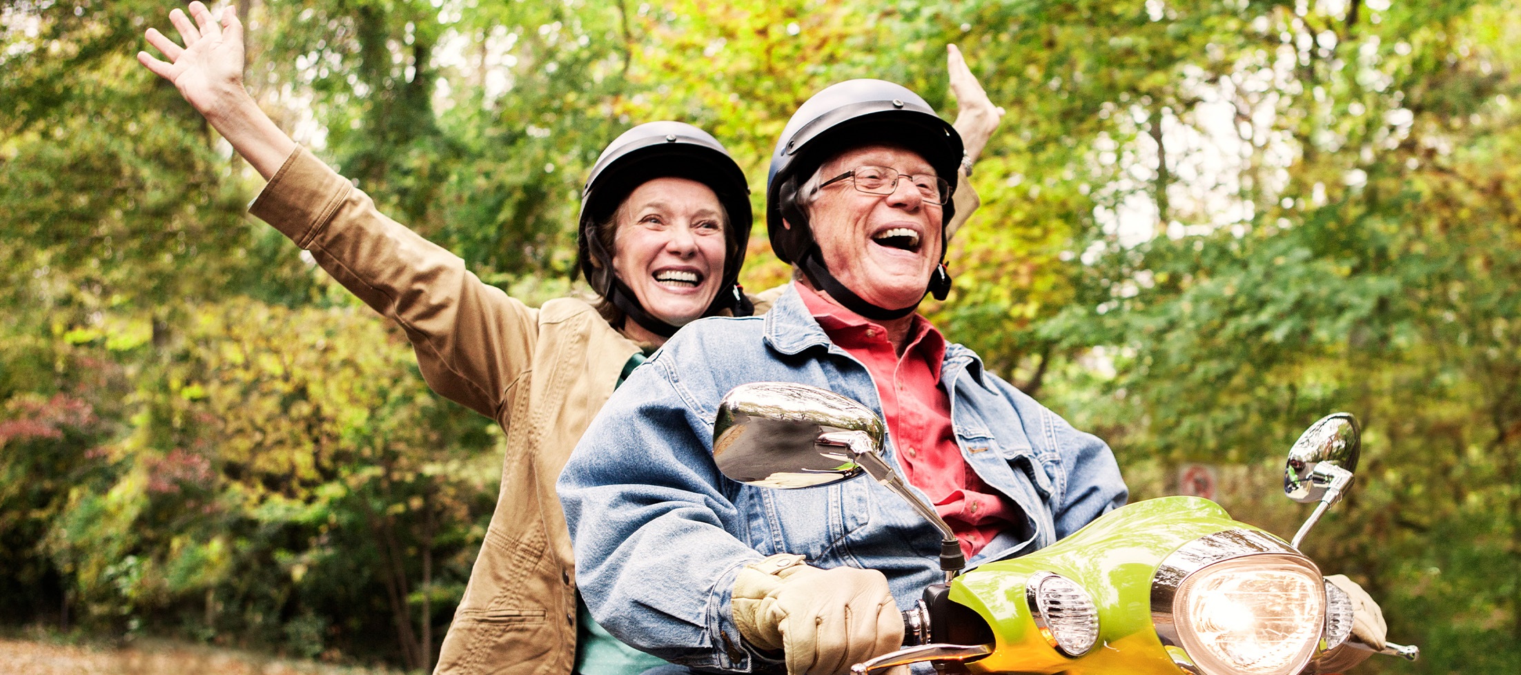 senior man and woman ride a moped