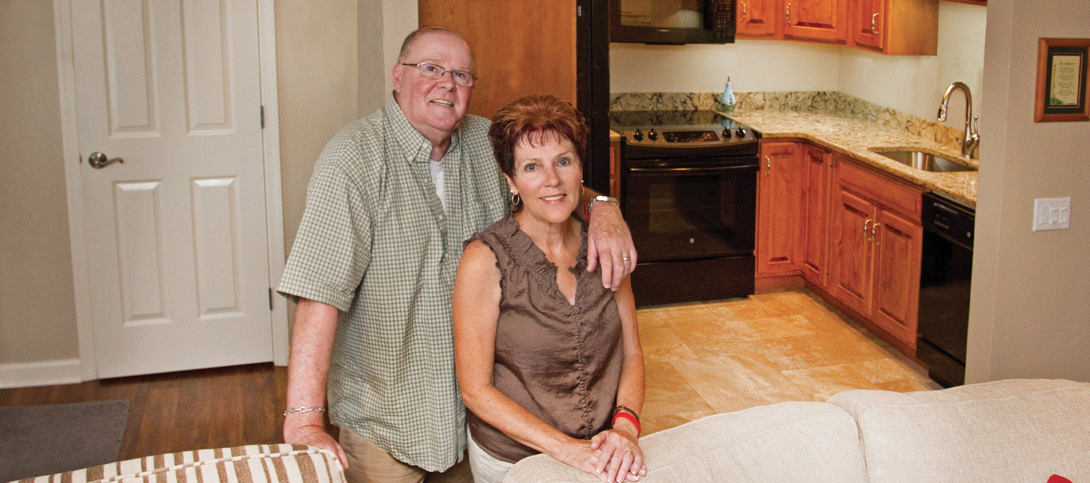 husband puts an arm around smiling wife