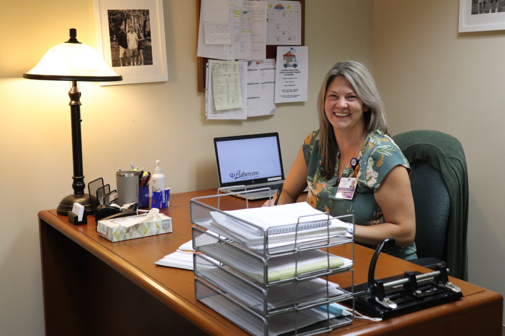 A smiling woman sitting at a desk